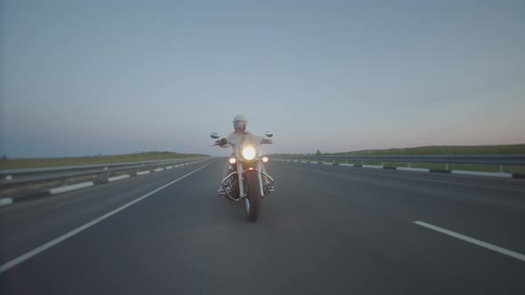 Confident Woman Rides Motorcycle with Helmet Highway with Headlight on