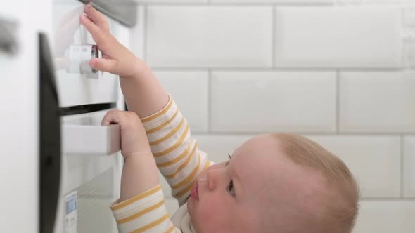 Curious Little Baby Opening Oven at Home in Kitchen