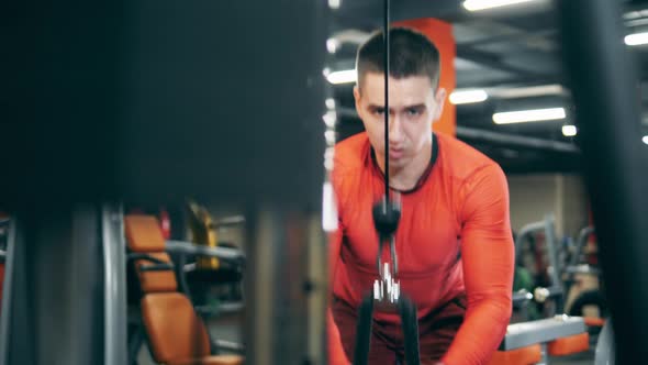 Male Athlete Is Doing an Exercise for Arms with a Fitness Machine