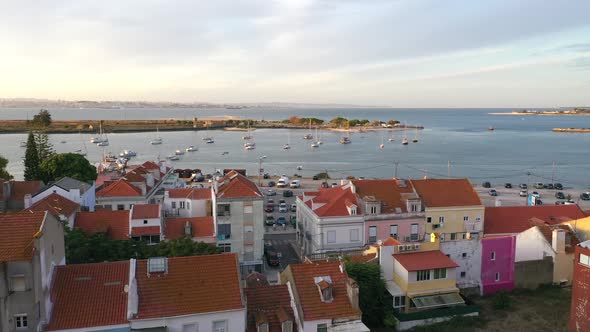 Aerial shot fly back through trees over seixaL bay and buildings - Portugal