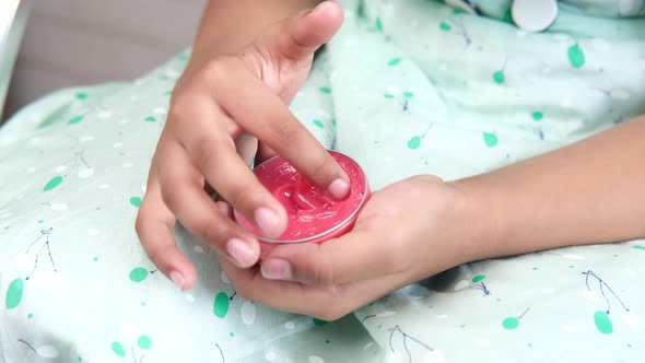 Child Girl Using Petroleum Jelly Onto Skin at Home Close Up