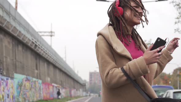 slow motion young woman outdoors dancing listening music