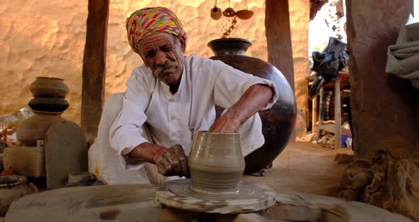 Skilled Professional Potter Throwing the Potter's Wheel and Shaping Traditional Ceramic Vessel and