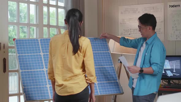 Asian Man And Woman Walk Into Discuss About Solar Cell In The Room