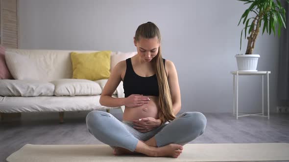 Healthcare and Prenatal Yoga womanSpbd Strokes Tummy on Floor