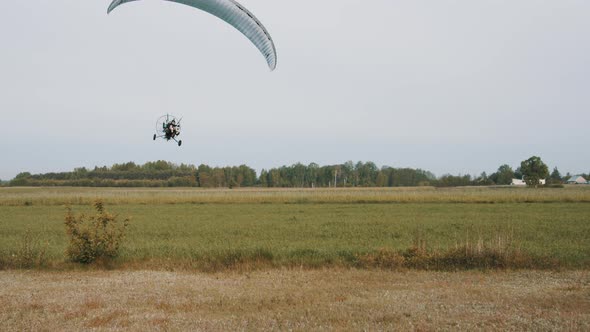 Landing with the Tandem Paramotor Gliding in Slow Motion. Wide Shot