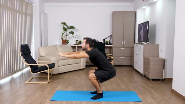 Sport at Home - Athletic Man Doing Squats in the Living Room