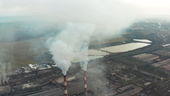 Industrial Zone with a Large Red and White Pipe Thick White Smoke Is Poured From the Factory Pipe