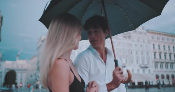 Couple holding umbrella and talking