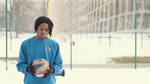 African American Guy with a Ball Is Training on the Court