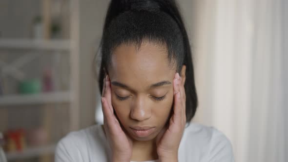 Closeup Overburdened Exhausted African American Female Freelancer Rubbing Temples Standing in Home