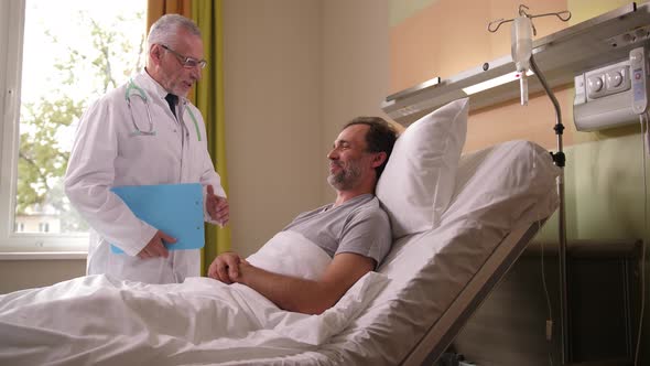 Physician Visiting Recovering Man in Hospital Ward