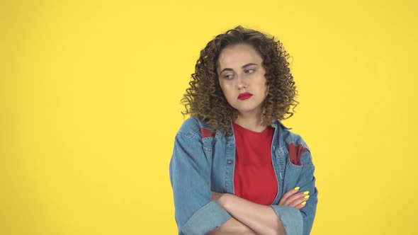 Lovely Girl Is Very Offended and Looks Away on Yellow Background at Studio, Slow Motion