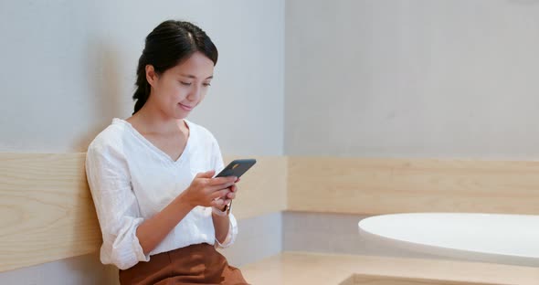 Woman use of smart phone inside coffee shop