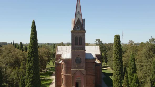 Jib up of beautiful romantic style church and tower surrounded by pine trees in Santa Anita town, En