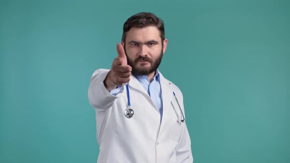 Doctor Man in Medical Coat Points Index Finger Into Camera Lens and Winks