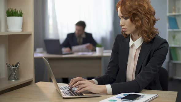 Female Employee in Suit Sitting at Work Desk and Typing on Computer Office Work