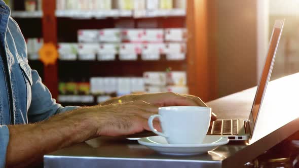 Man using laptop while having tea in caf������������