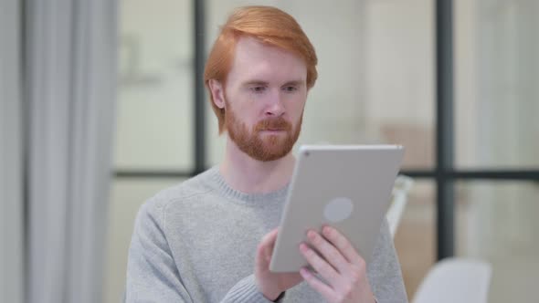 Portrait of Young Redhead Man Using Digital Tablet