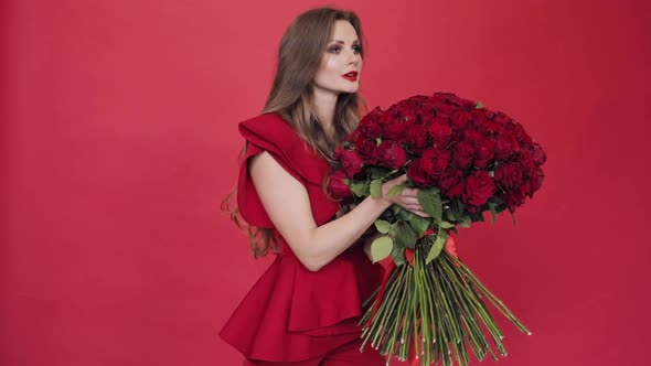 Brunette Girl with Long Hair in Red Blouse Turning Flowers