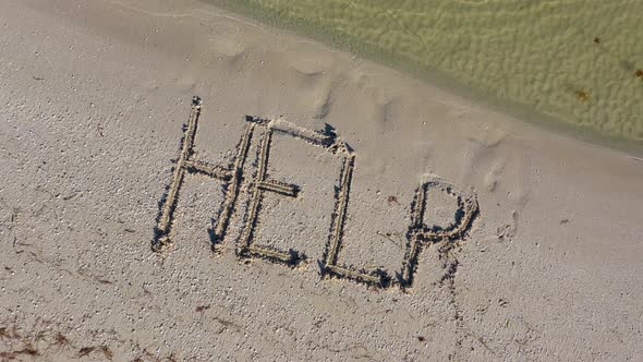 HELP written in the sand gets larger.