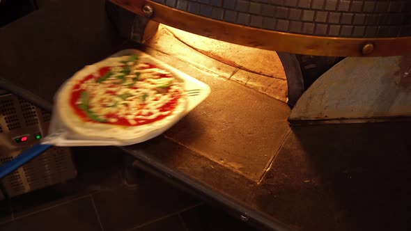 Putting Fresh Pizza Into Hot Oven