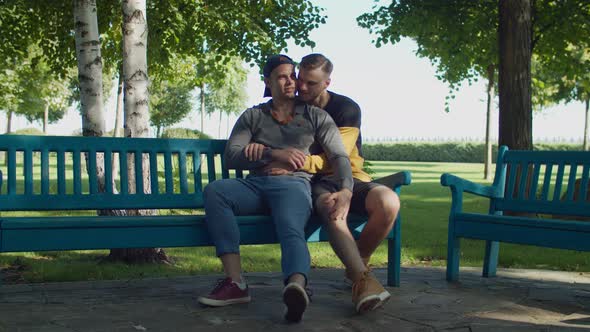 Romantic Same-sex Male Couple Cuddling on Park Bench