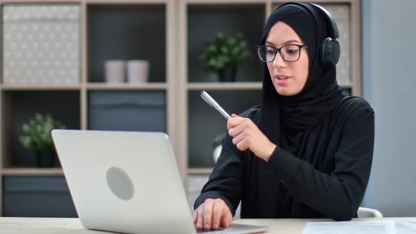 Muslim Business Woman in Headset Talking Online Video Call Use Laptop Working Studying Remotely
