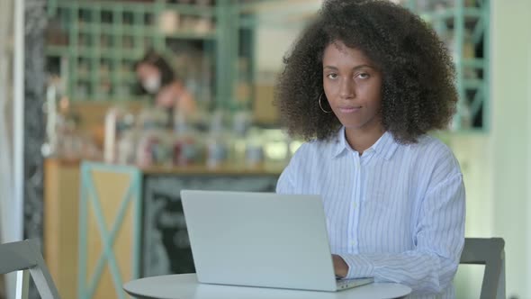 Thumbs Up By Young African Businesswoman Working in Cafe