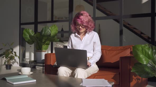 Young Woman Using Laptop at Home Office Working Online Sitting on Sofa