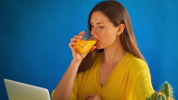 Woman in a Yellow Blouse Works Remotely at Home During a Pandemic