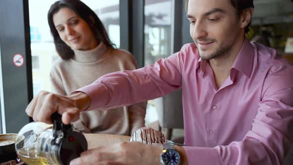 A Young Couple is Discussing Something in a Cafe