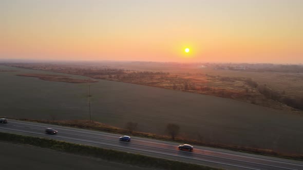 Aerial View of Intercity Road with Fast Driving Cars at Sunset