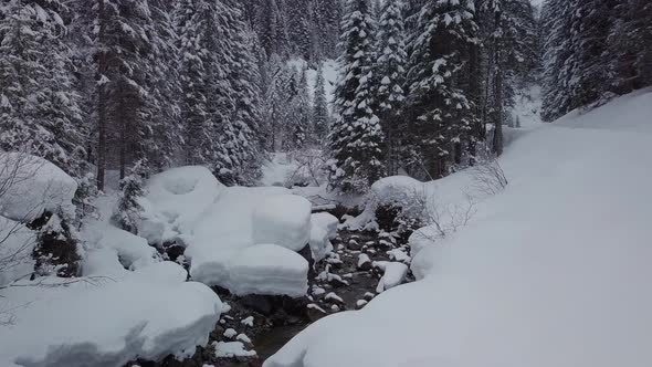 winter wonderland in the alps. A small valley with a snowy creek, Kleinwalsertal, Austria