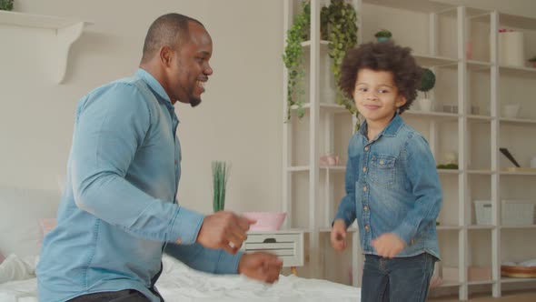 Joyful Black Father and Cute Son Dancing at Home