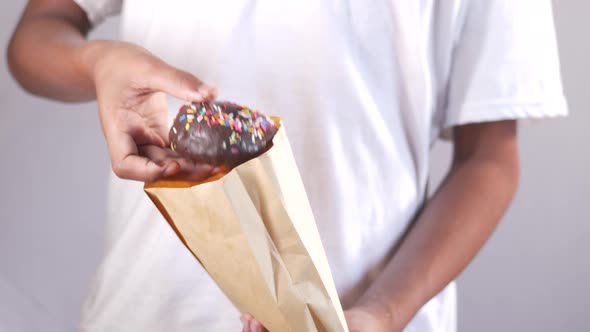 Young Man Taking Donuts Out From a Packet