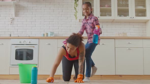 Carefree Daughter Piggybacking Mom During Cleaning