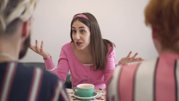 Portrait of Excited Young Retro Woman Talking to Friends Sitting in Vintage Coffee Shop Indoors