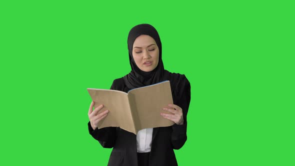 Surprised Muslim Businesswoman Reading Business Diary and Shaking Her Head While Walking on a Green