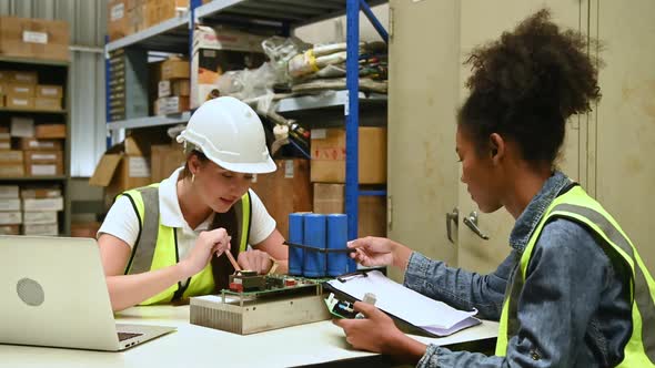 Two female warehouse worker Counting items in an industrial warehouse 