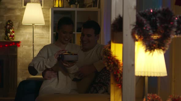 Young Woman Opening Gift with Magical Shine