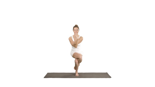 Attractive girl standing in the balancing yoga pose Garudasana