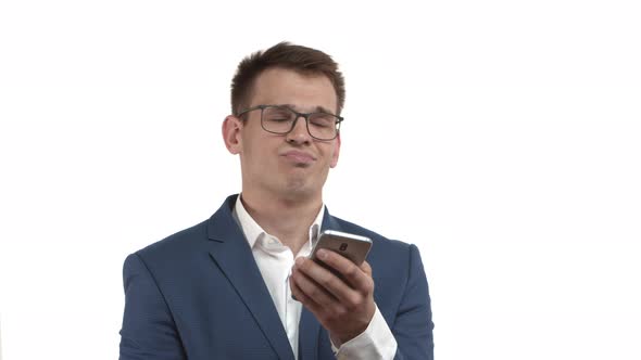 Closeup of Handsome Businessman with Blond Hair Wearing Blue Suit and Glasses Looking at Mobile