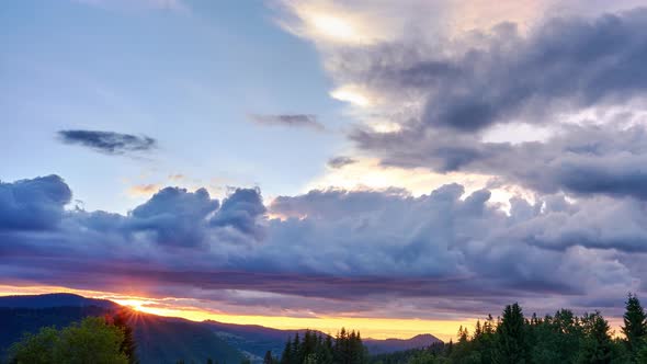 Colorful Clouds in Fast Motion Over Green Hilly and Forest Landscape in Summer