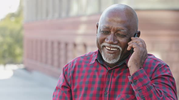 Overjoyed Senior 80s Black Grandfather Laugh Talking on Modern Cellphone Happy Mature 70s African