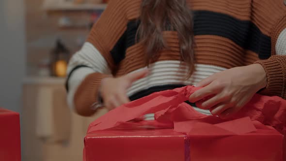 Close Up of Woman Wrapping Bow on Gift for Friends