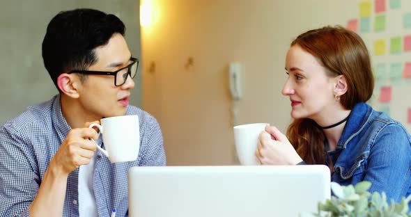 Business executives interacting while having coffee