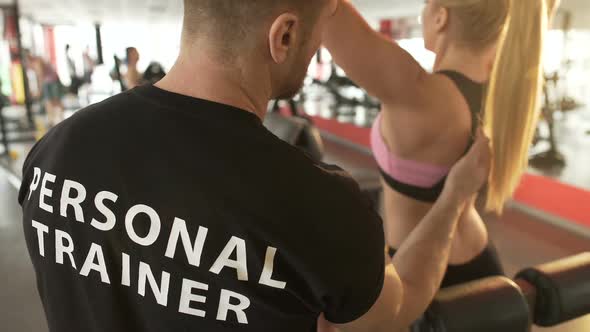 Gym Trainer Explaining Pull-Down Technique to Female Trainee, Professional Help