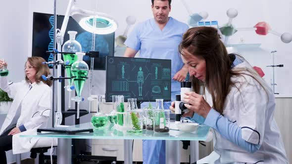 Female Biology Scientist Looking at Samples Under the Microscope