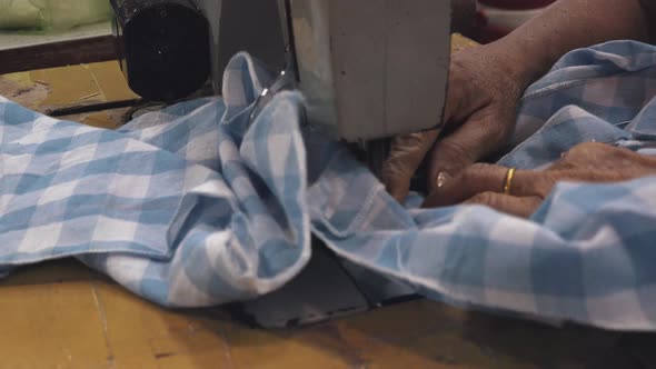 A Seamstress Working on a Shirt Using a Sewing Machine Close